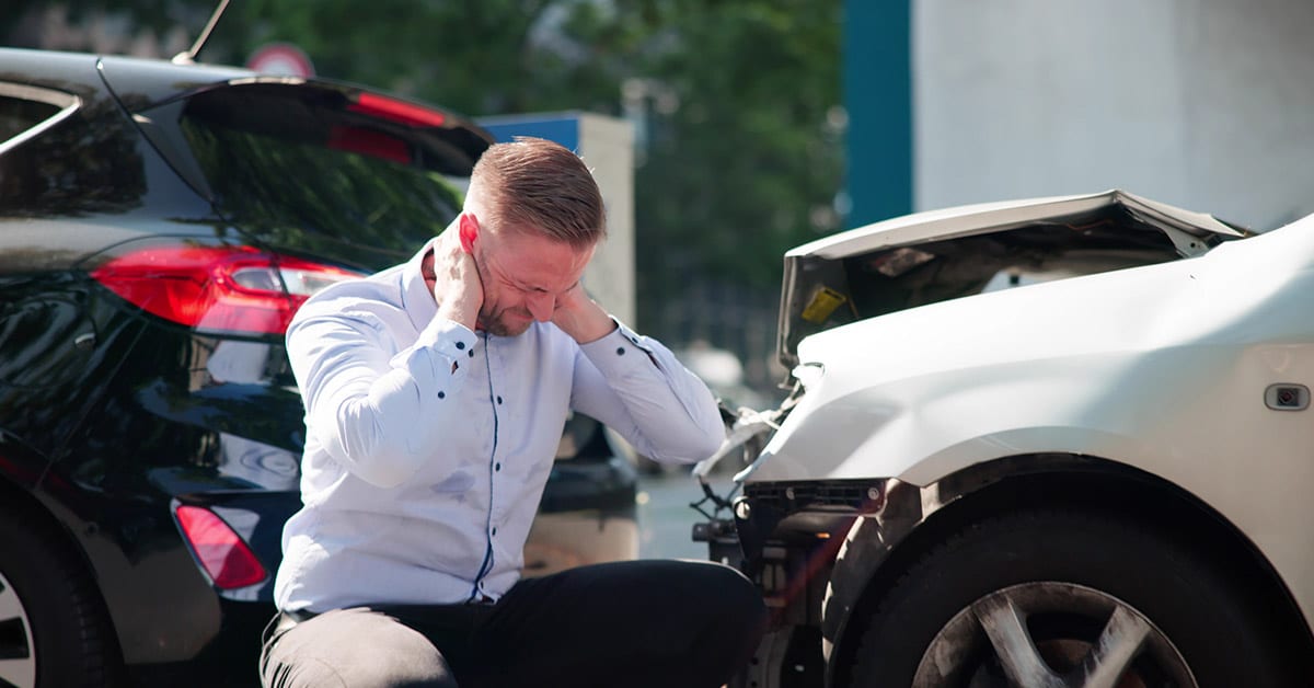man holding neck after car crash