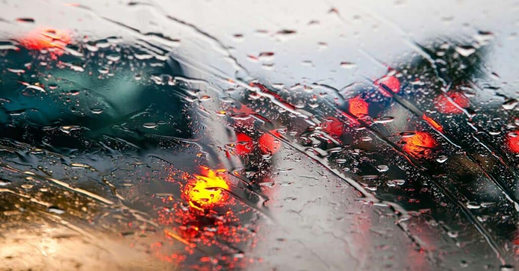 rain windshield blurred traffic red lights